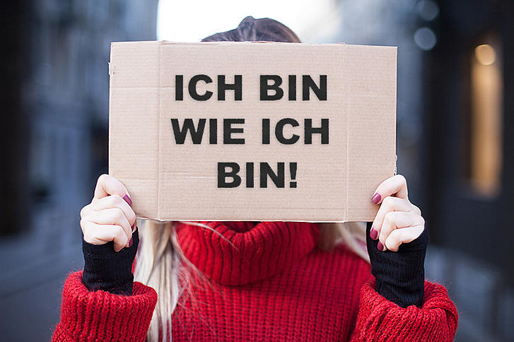 Mädchen hält Plakat in der Hand mit der Aufschrift "Ich bin wie ich bin"